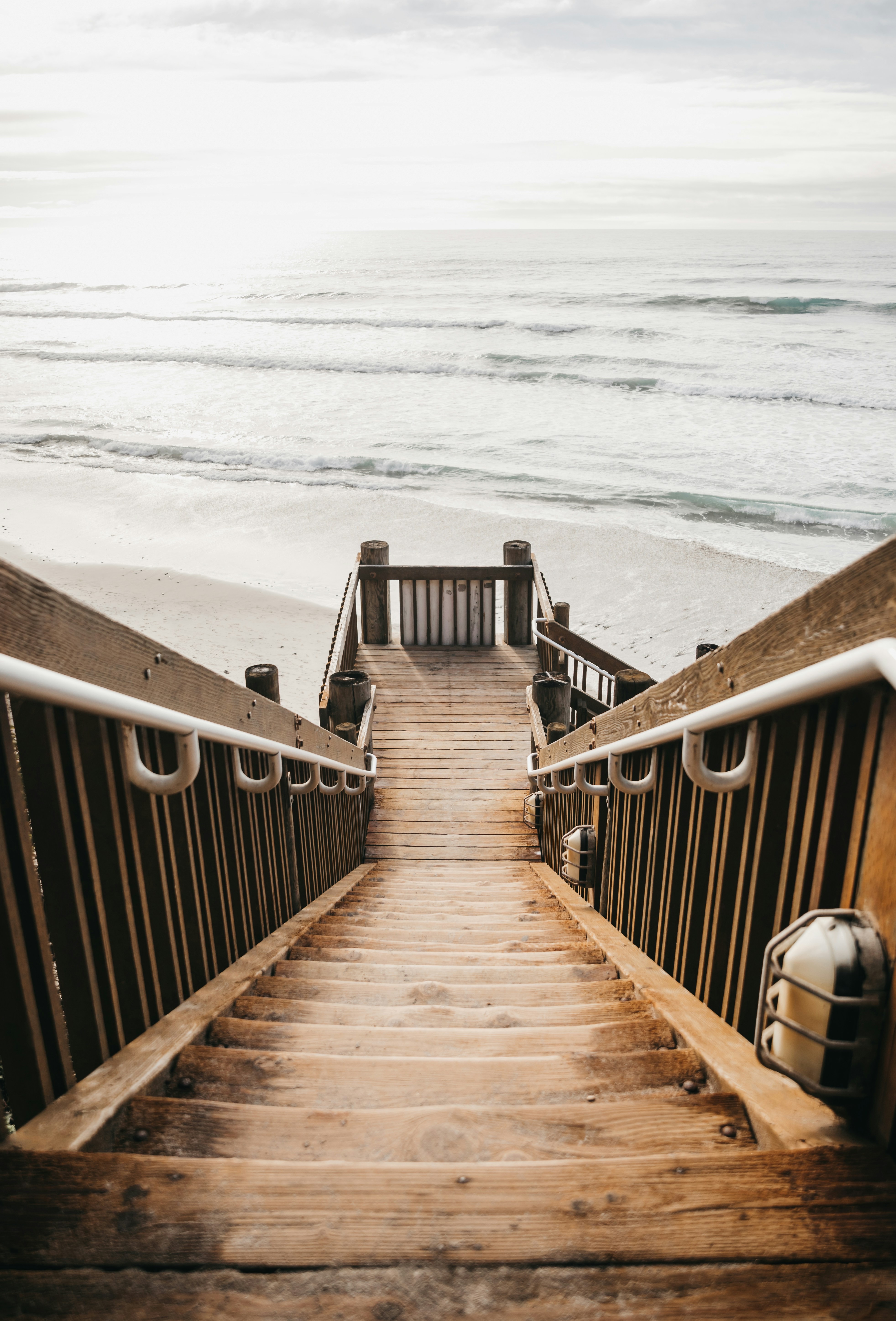 Wooden beach stairs leading down to the sand and surf in Encinitas