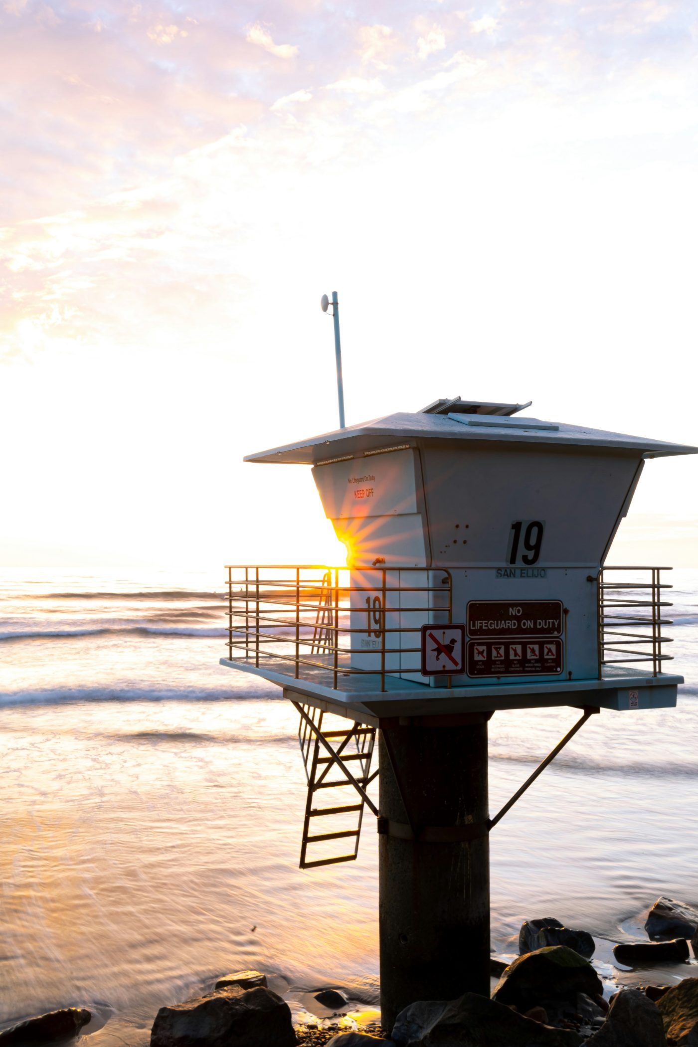 Lifeguard tower 19 at San Elijo State Beach with the sun setting behind it